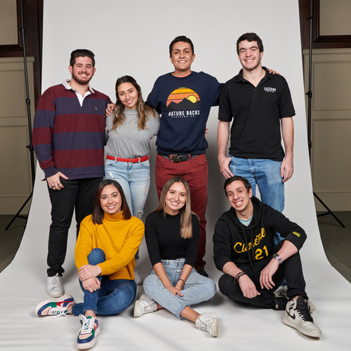 Group of students posing for a photo in front of a white screen.