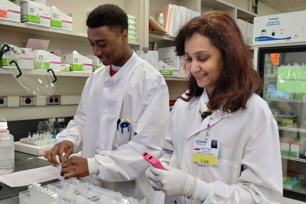 Medical technologist and student handling items in medical lab