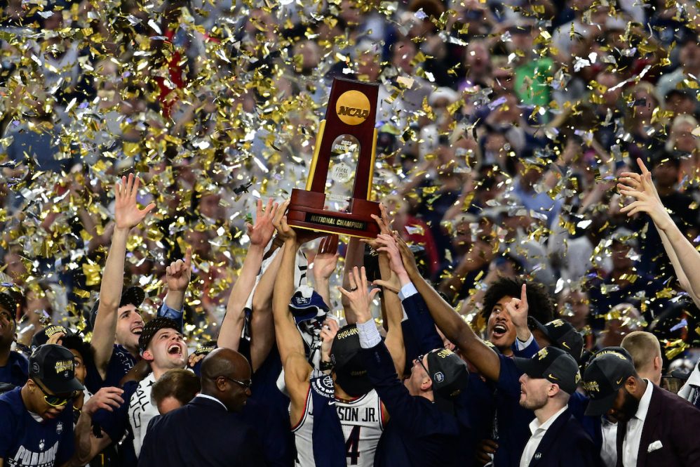 UConn Men's Basketball team hoisting the NCAA trophy