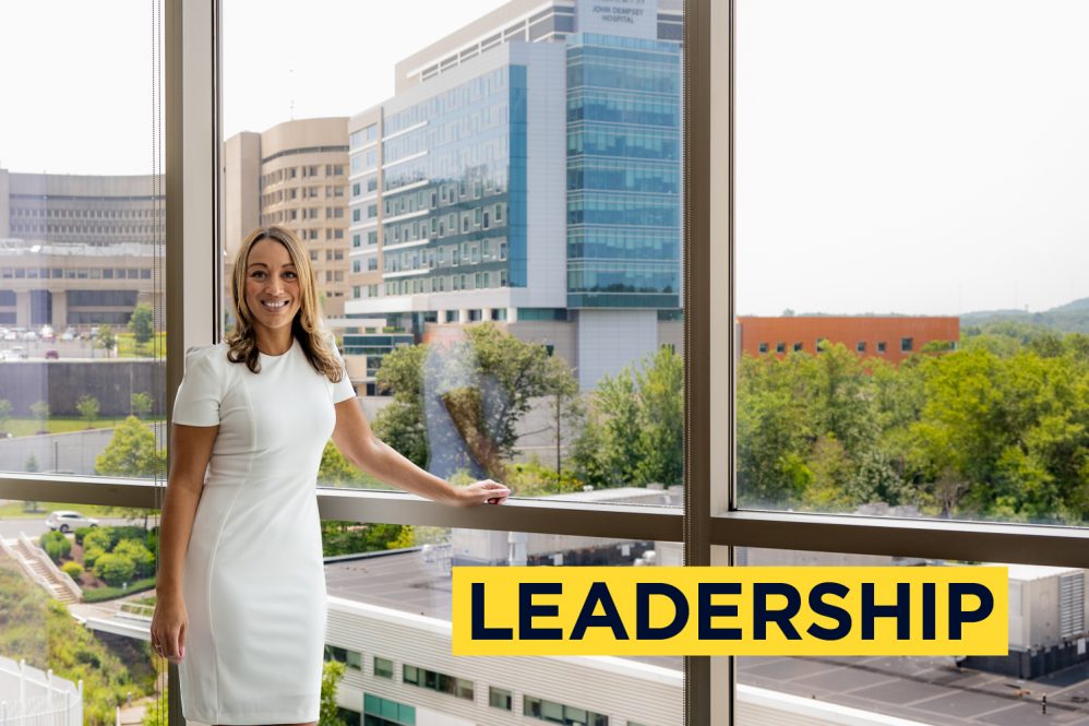 Portrait in front of open window with hospital tower in background