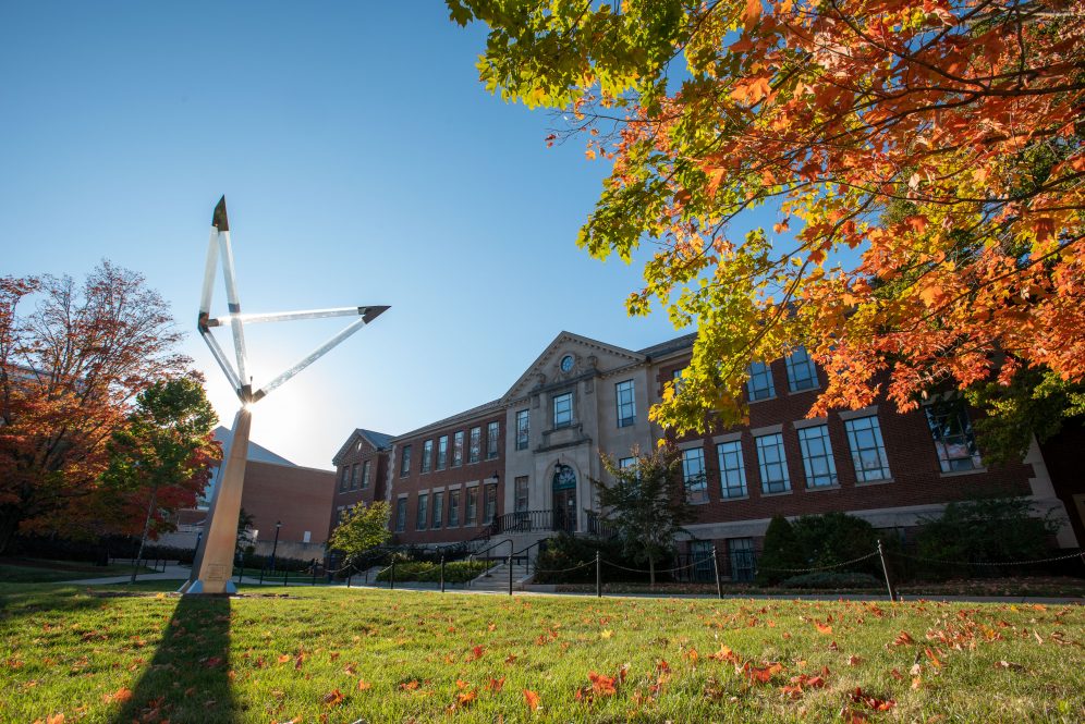 Fall foliage (leaves) in front of the prism sculpture and the School of Engineering