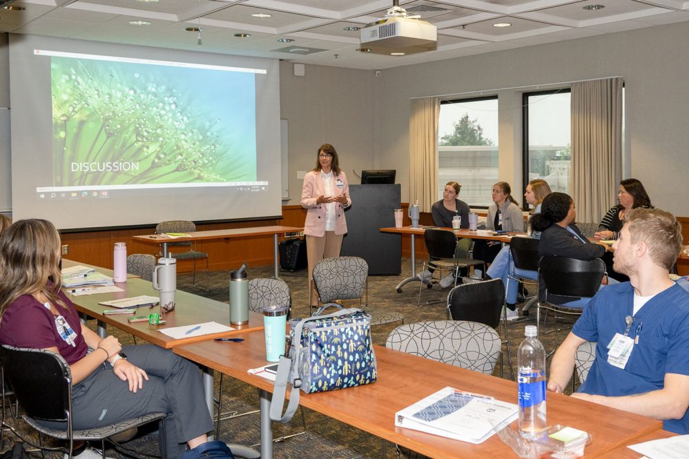 Woman speaking to group in conference room.