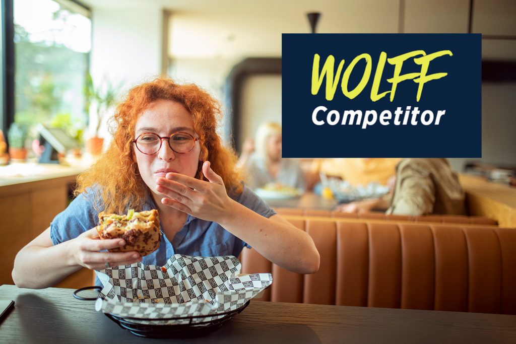 A woman eats a sandwich in a fast-food restaurant.