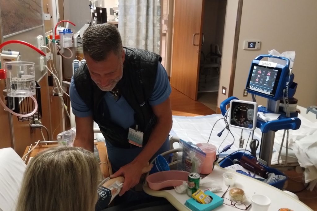 Medical assistant with patient in hospital room