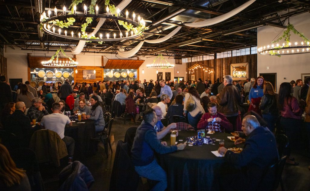 A large crowd of people are in a Connecticut brewery for the launch of a new beer made by UConn students.