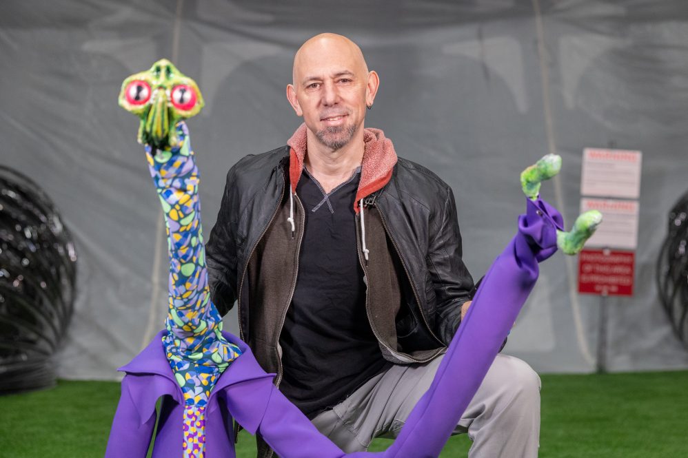 Jaron Hollander '24 poses with one of the puppets from "War of the Worlds 2023" in the Nafe Katter Theatre