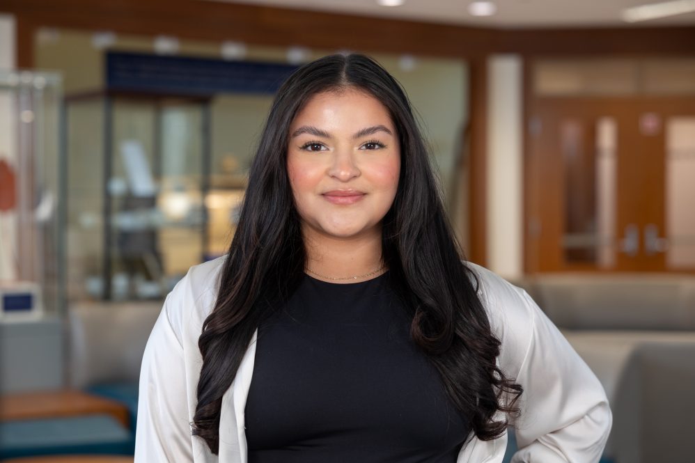 Kimberly Rosado '24 poses for a photo in the Widmer Wing of Storrs Hall