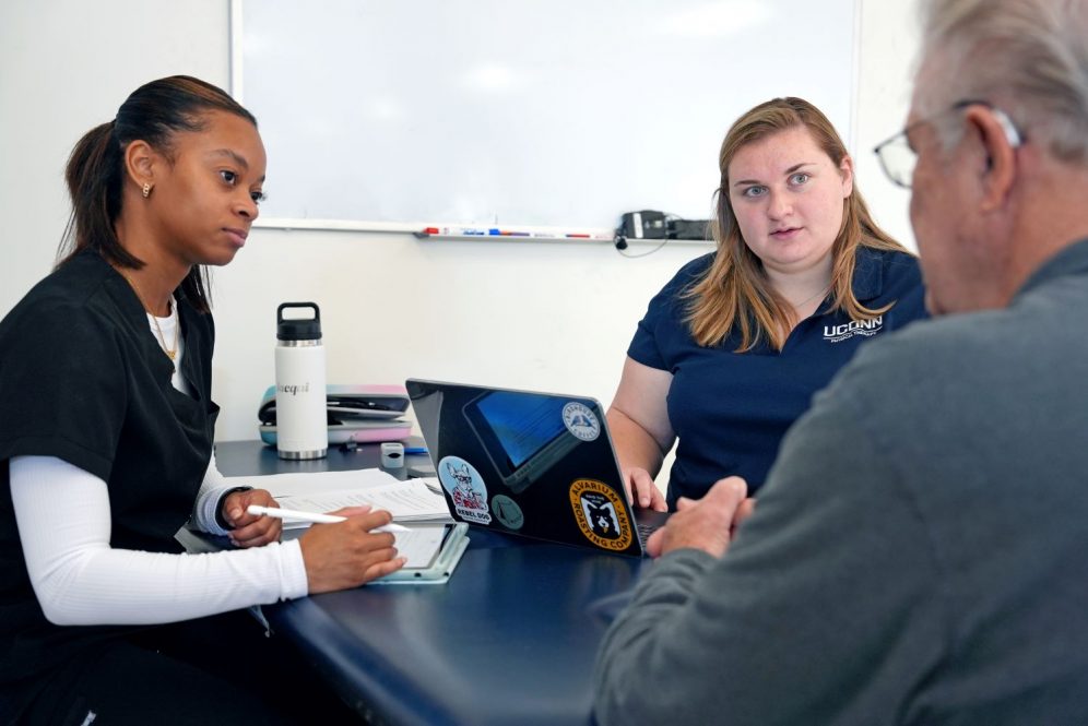 Female students speak with a patient