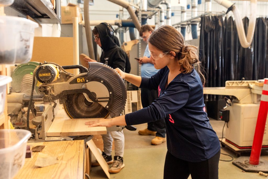 Female student working with a saw