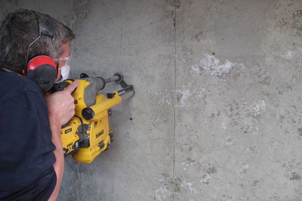 Man drills core sample in foundation.