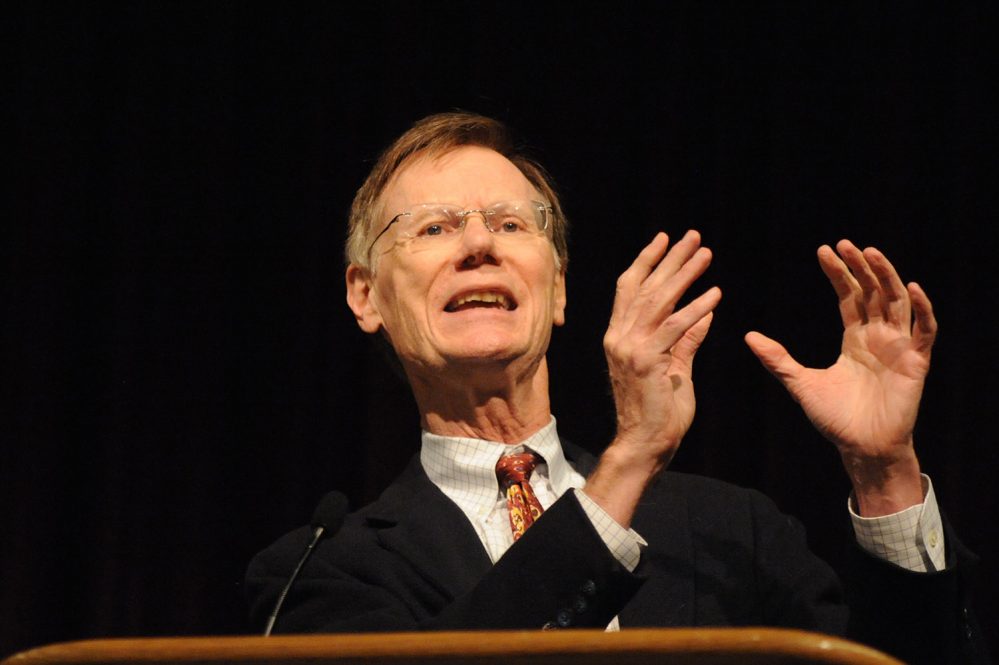 Stephen Bright stands at a podium, gesturing as he speaks.