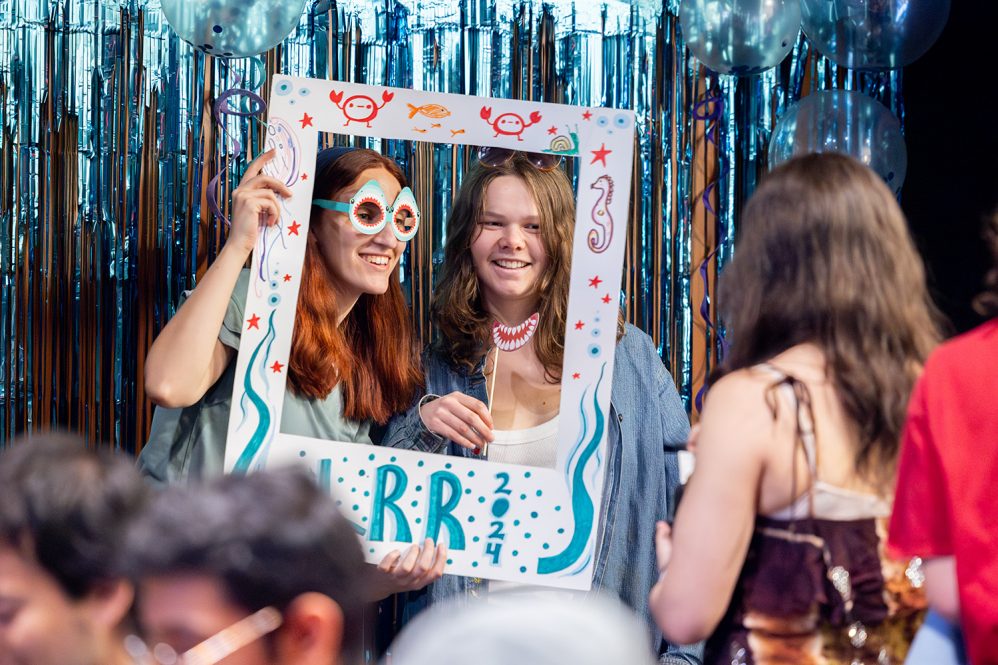 Students pose for a photo with a cardboard poster.