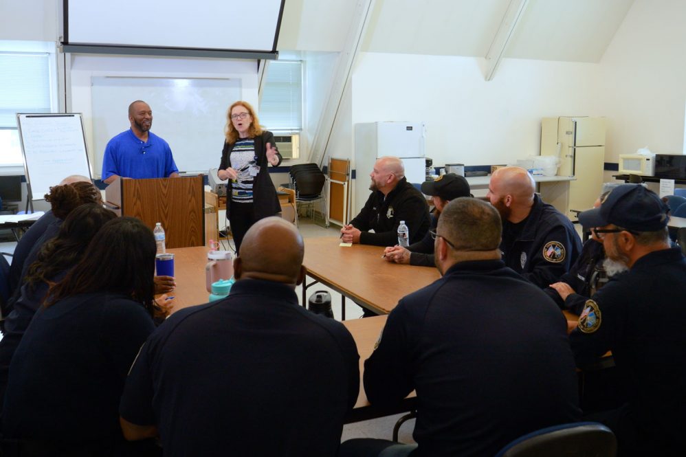 Two instructors leading a discussion with correction workers in a classroom setting