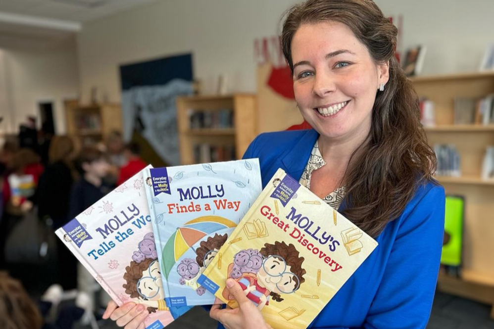 Krista Weltner shares her series of illustrative children's books, "Molly Tells the World", "Molly finds a Way", and "Molly's Great Discovery", all featuring a precocious child and a purple creature, both in matching glasses, on the cover.