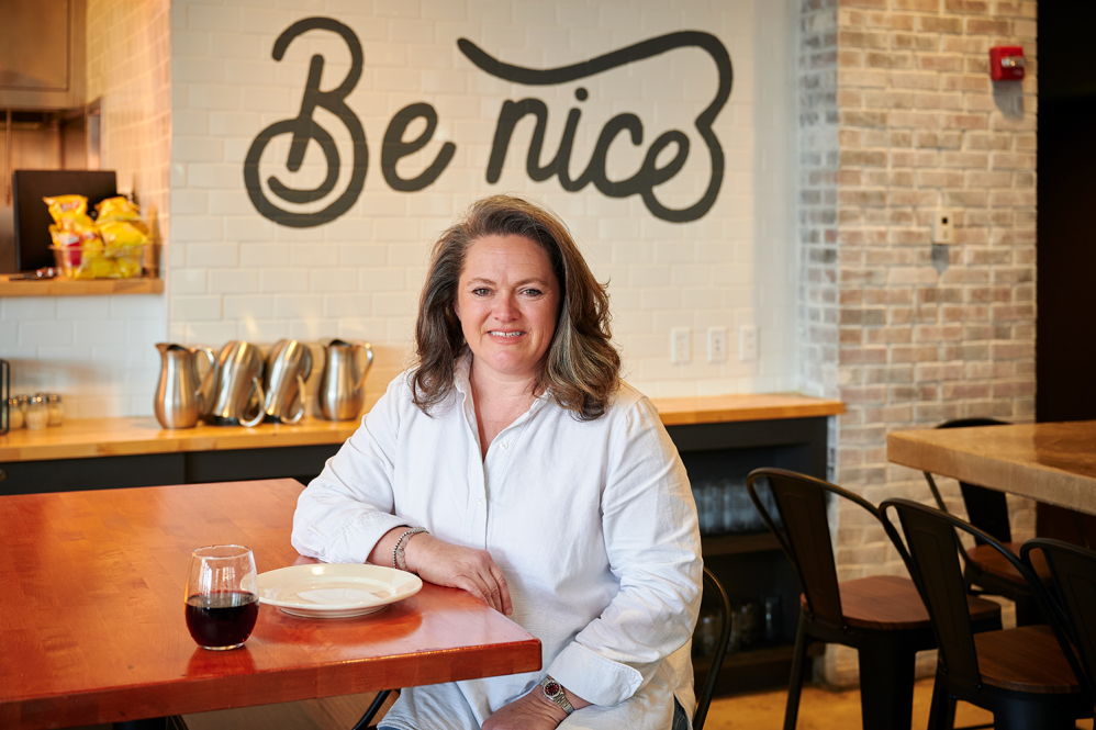 One of the owners of Square Peg Pizza poses in a restaurant.