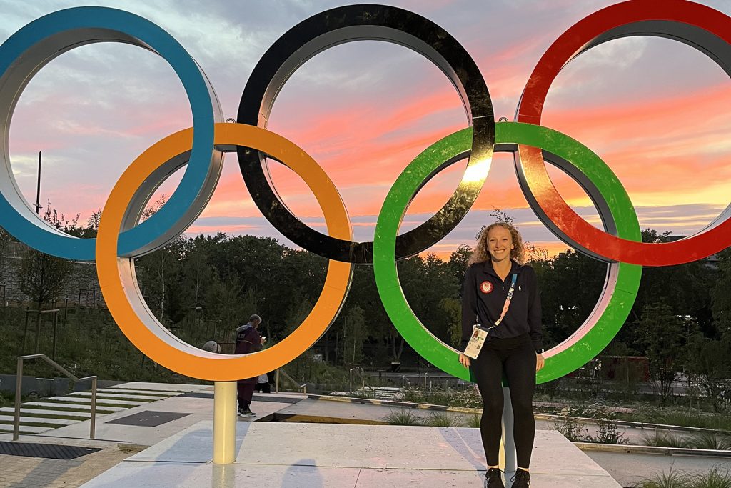 Kelli Bates standing in front of Olympic rings in Paris, France.