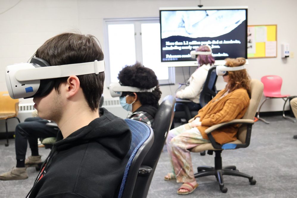 E.O. Smith High School students use a virtual reality exhibit to learn about the Holocaust.