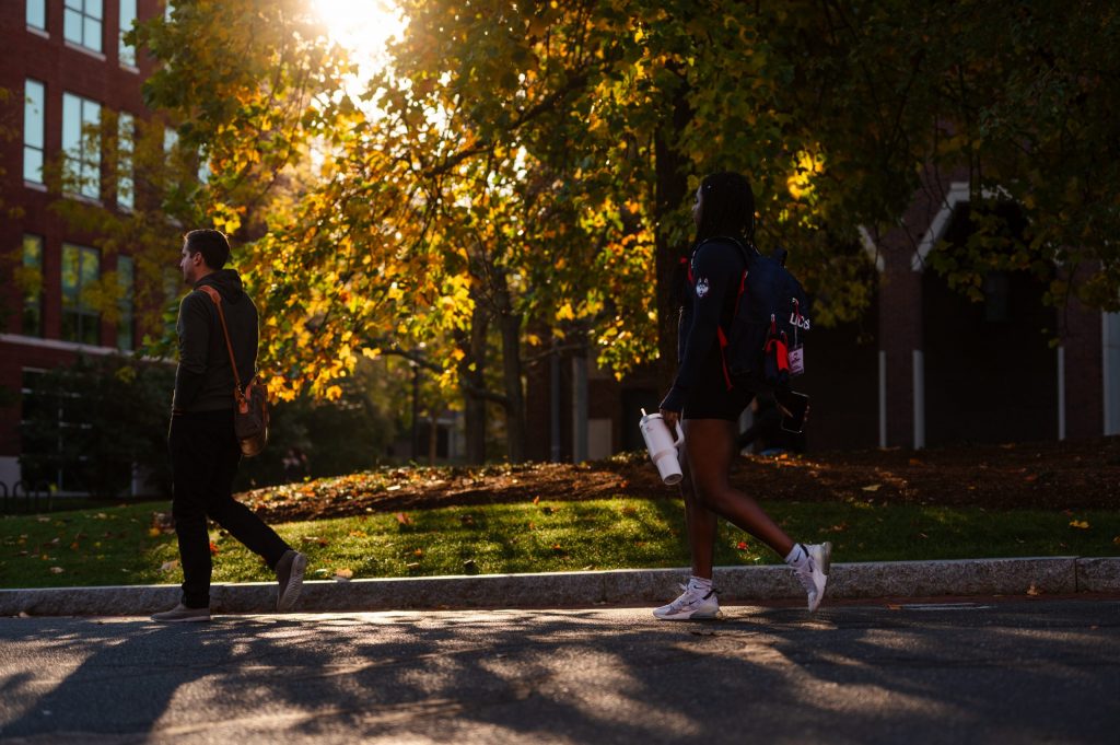 Students walk across the campus at UConn Storrs in the autumn.