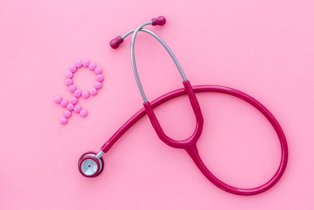 Medical concept with Venus sign and stethoscope on pink background top-down.