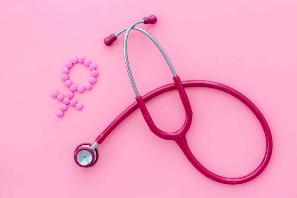 Medical concept with Venus sign and stethoscope on pink background top-down.