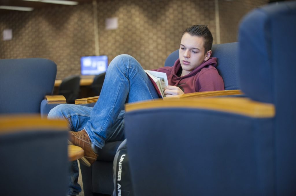 A student at the Homer Babbidge Library, reading.