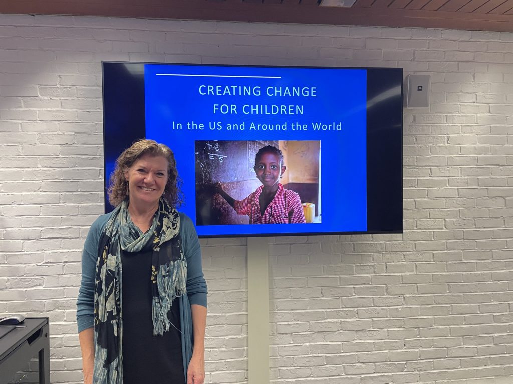 Human rights activist Jo Becker stands in front of a screen showing her presentation.