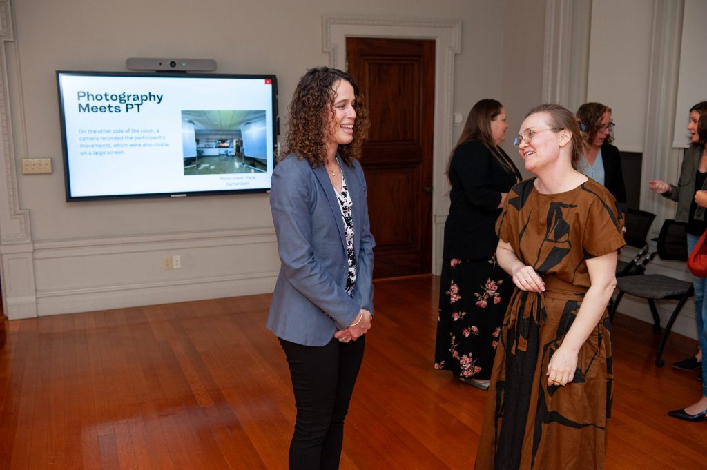 Cristina Colón-Semenza, assistant professor in UConn’s Department of Kinesiology, talks with Clare Benson, a former UConn assistant professor of photography, at the Nov. 7 opening of their exhibition, "On the Move: Photographic Interventions in the Future of Parkinson's Disease," at the Alexey von Schlippe Gallery of Art at UConn Avery Point.