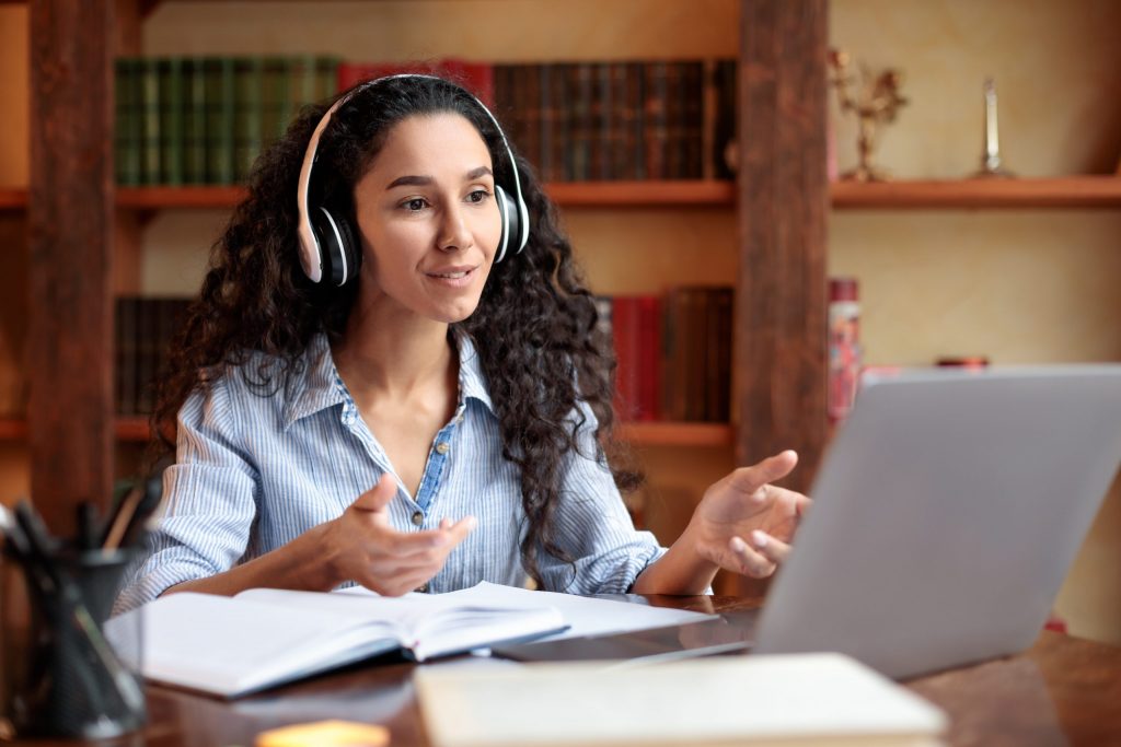 Woman sitting at desk, having video call on computer