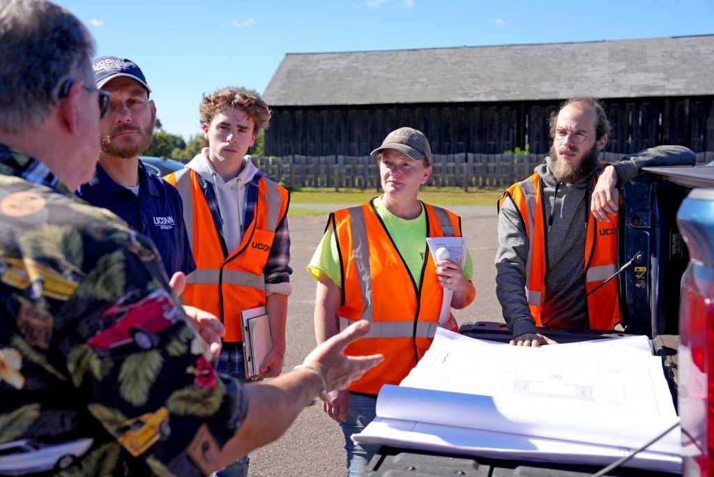 People standing around a truck looking at maps