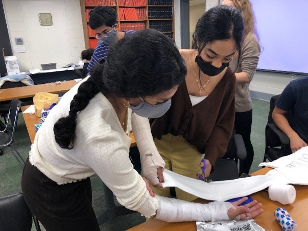 Students learning how to create a splint on each other